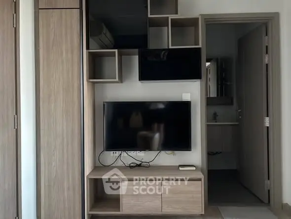 Modern living room with sleek TV unit and open bathroom view