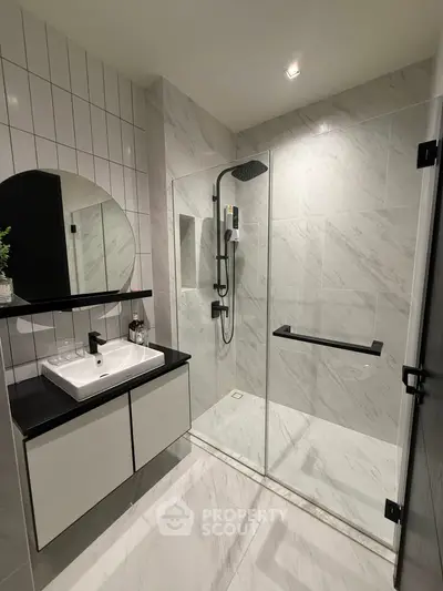 Modern bathroom with sleek shower and stylish vanity in luxury apartment.