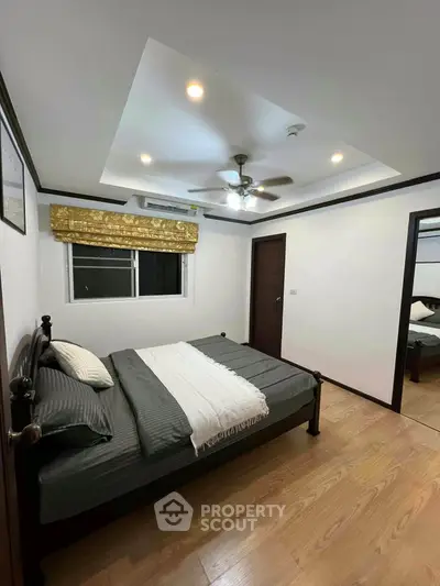 Spacious bedroom with modern ceiling fan and wooden flooring
