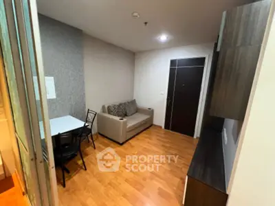 Cozy living room with modern decor and wooden flooring in a compact apartment.