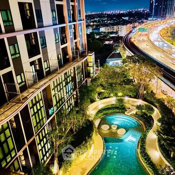 Stunning night view of modern apartment building with illuminated pool and lush garden.
