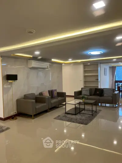 Spacious modern living room with elegant lighting and stylish furniture in a luxury apartment.