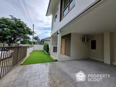 Spacious modern home with covered parking and lush green lawn in a serene neighborhood.