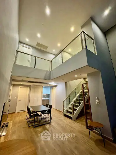 Stunning modern duplex with high ceilings and sleek staircase, perfect for contemporary living.