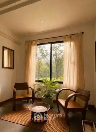 Cozy living room with wooden chairs, large window, and lush greenery view.