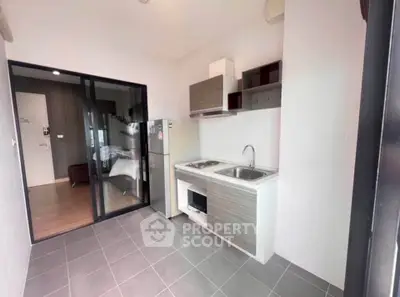 Modern open-layout kitchen with sleek appliances and adjacent bedroom view.
