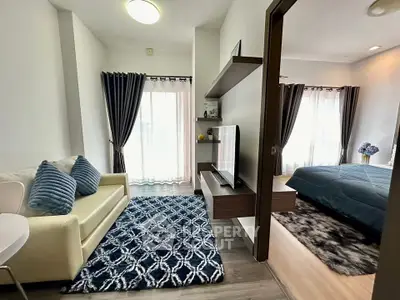 Modern studio apartment with stylish living area and cozy bedroom, featuring elegant decor and natural light.