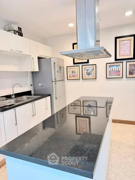 Modern kitchen with sleek black countertop and stainless steel appliances.