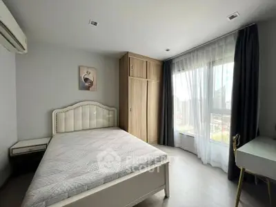 Bright and airy bedroom with large window and modern furnishings in a high-rise apartment.