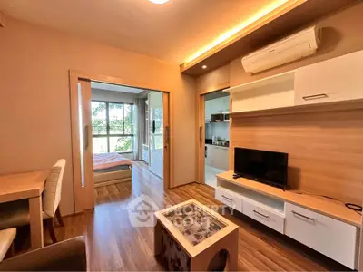 Modern apartment interior with open living room and bedroom, featuring stylish furniture and natural light.