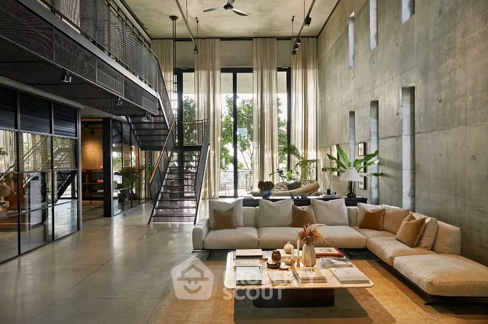 Luxurious modern living room with high ceilings and large windows offering natural light.