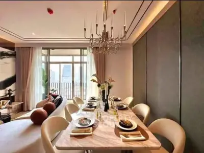 Luxurious open-plan living and dining area with elegant chandelier and city view balcony.