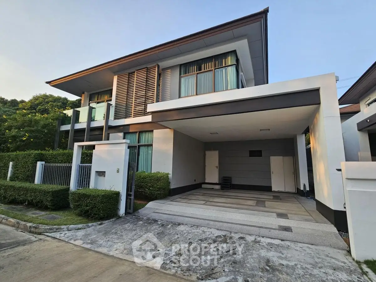 Modern two-story house with spacious driveway and sleek architectural design.