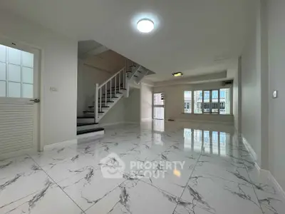 Spacious modern living room with marble flooring and staircase