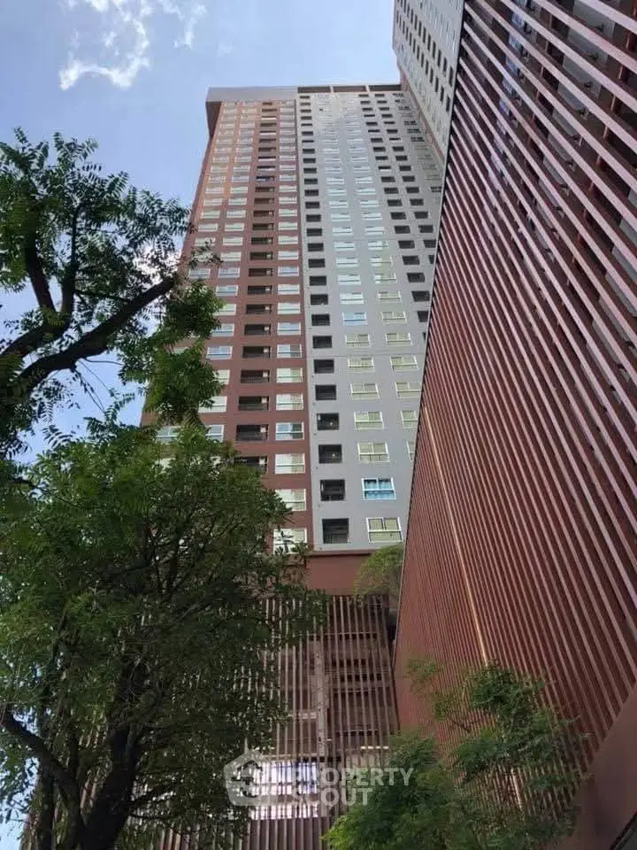 Stunning high-rise building with modern architecture and lush greenery, perfect for urban living.