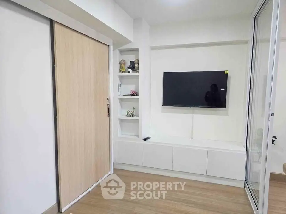 Modern living room with sleek TV setup and wooden sliding door