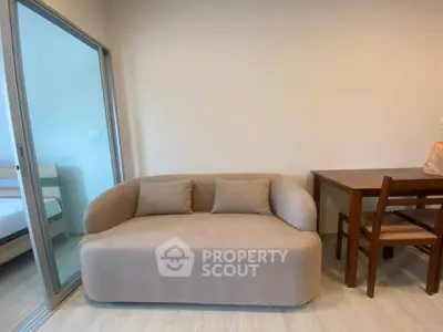 Cozy living room with modern beige sofa and wooden dining set