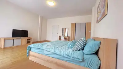 Spacious modern bedroom with stylish wooden furniture and cozy blue bedding