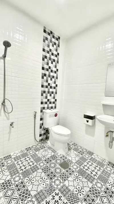 Modern bathroom with stylish black and white tiles and sleek fixtures.