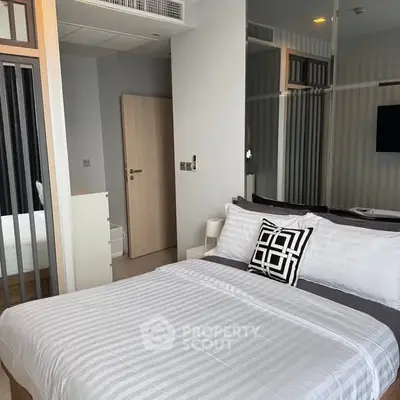 Modern bedroom with stylish decor and comfortable bedding in a contemporary apartment.