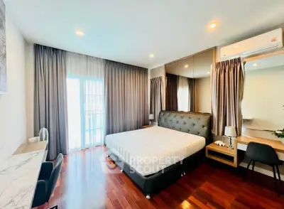 Spacious bedroom with elegant decor and large windows for natural light