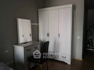 Charming bedroom with elegant white wardrobe and matching vanity set, perfect for stylish storage solutions.