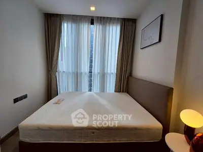 Cozy bedroom with large window and modern decor in a stylish apartment.