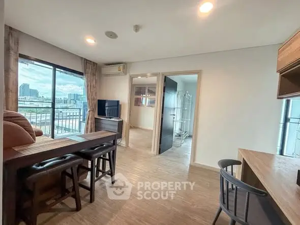 Modern apartment interior with open layout and city view from balcony.