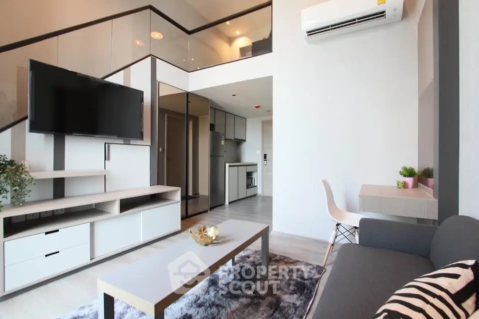 Modern living room with mezzanine, sleek furniture, and open kitchen layout in stylish apartment.