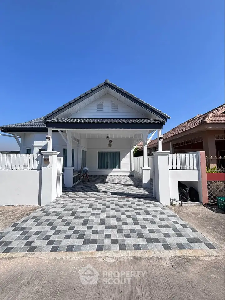 Charming single-story house with spacious driveway and modern exterior design.