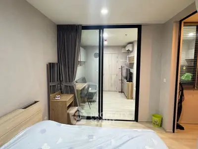 Modern bedroom with sliding glass doors leading to a cozy study area