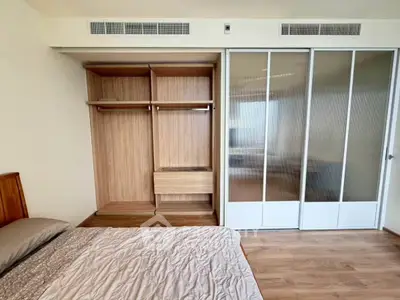 Spacious bedroom with built-in wooden wardrobe and sliding glass doors