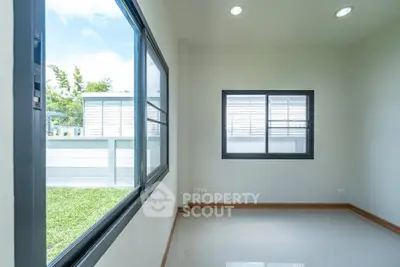 Bright room with large windows overlooking a lush garden, perfect for a serene living space.
