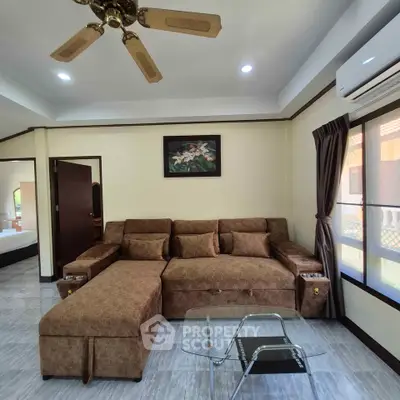 Cozy living room with brown sectional sofa and glass coffee table, perfect for relaxation.