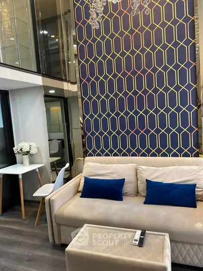 Modern living room with stylish geometric wall design and cozy seating area.