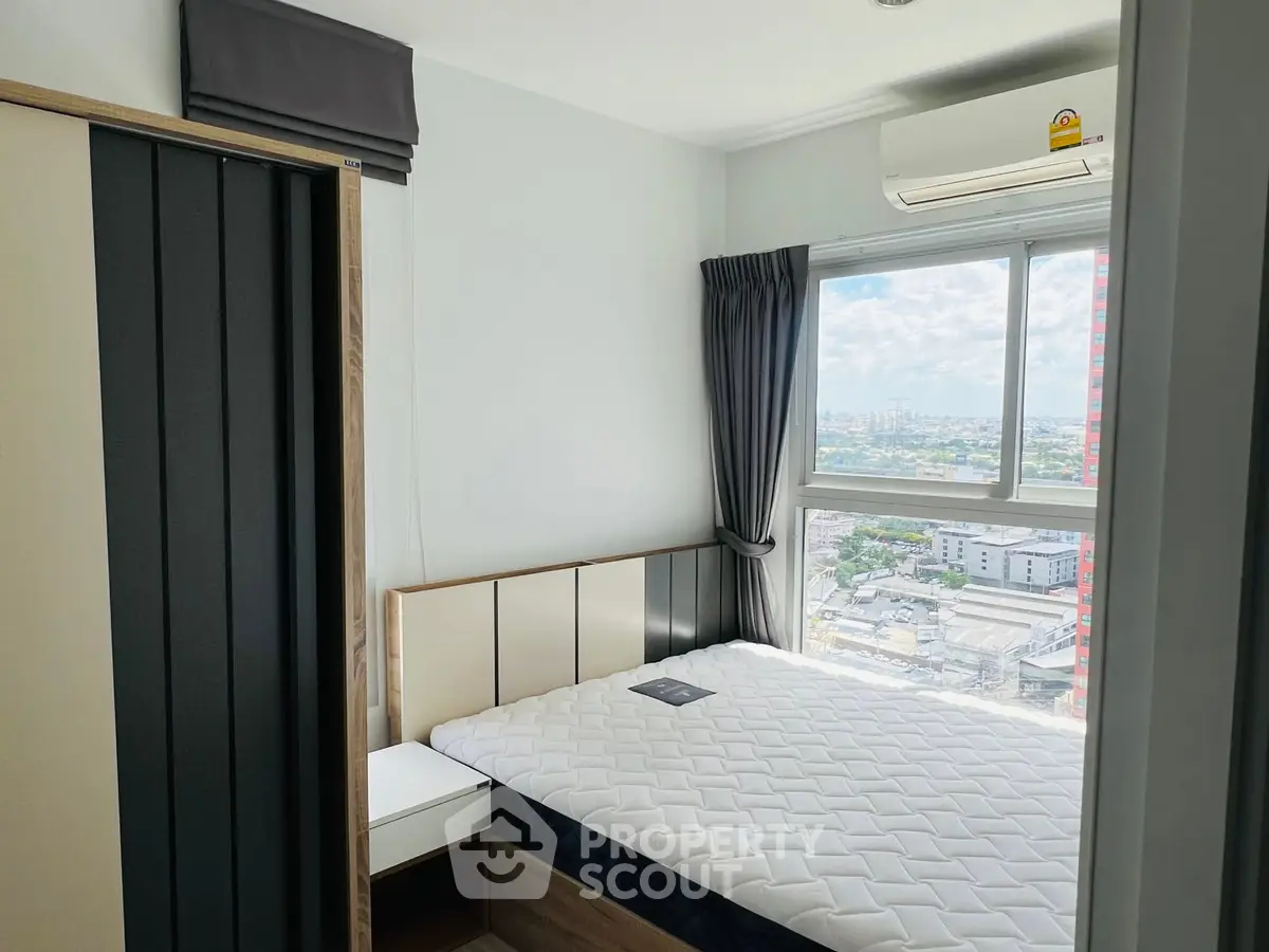 Modern bedroom with city view, featuring a comfortable bed and air conditioning.