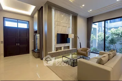 Luxurious modern living room with elegant decor and large windows overlooking a garden.