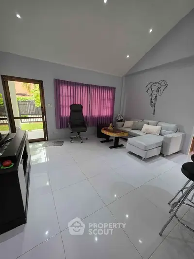 Modern living room with sleek furniture and natural light, perfect for relaxation and entertainment.