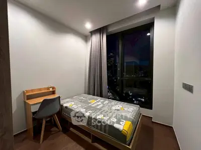 Modern bedroom with city view, featuring a single bed and study desk, perfect for urban living.