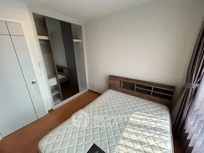 Spacious bedroom with large window and built-in closet in modern apartment.