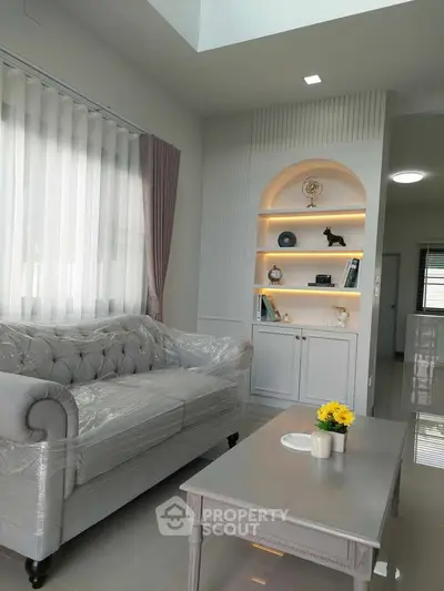 Elegant living room with plush sofa and decorative shelves in modern home.