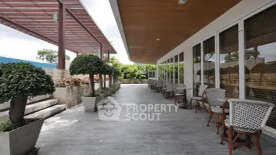 Spacious outdoor terrace with elegant seating and lush greenery, perfect for relaxation and social gatherings.