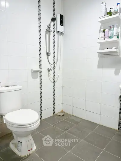 Modern bathroom with tiled walls and floor, featuring a shower and toilet.