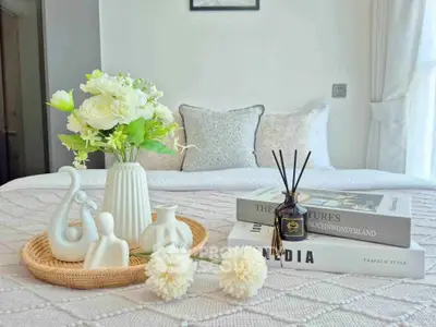 Elegant bedroom decor with stylish books and floral arrangement on a cozy bed, perfect for modern living.