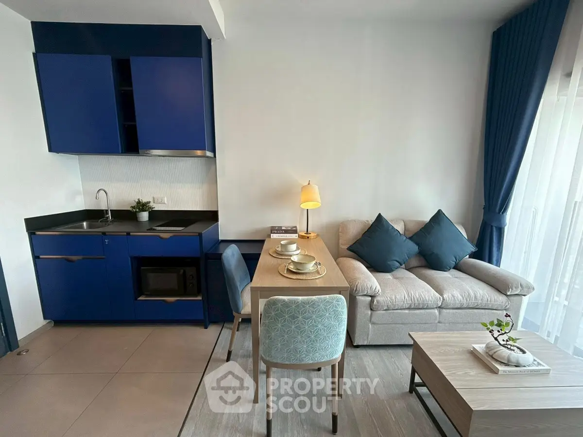 Modern living room with blue kitchen cabinets and cozy dining area