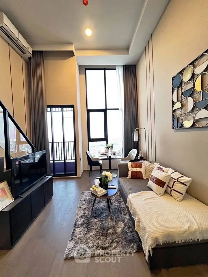 Modern living room with high ceilings and large windows offering stunning city views.