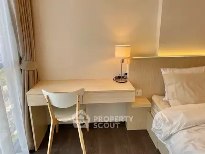 Modern bedroom with sleek desk and cozy lighting, perfect for a serene living space.