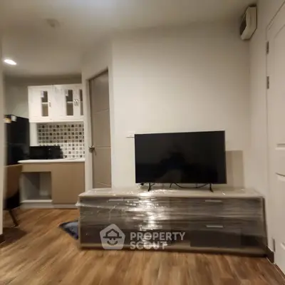Modern living room with sleek TV stand and cozy workspace in stylish apartment.