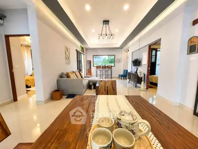 Spacious living room with modern decor and open layout, featuring elegant lighting and cozy seating area.