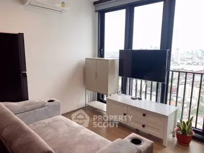 Modern living room with city view, featuring sleek furniture and large windows for natural light.